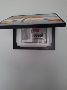 a microwave oven on a shelf on a wall at Heavenly joy in Patra +12 photos