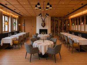 a row of tables in a restaurant with white tablecloths at Hotel Steffisalp - Ski-in & Ski-out am Arlberg in Warth am Arlberg
