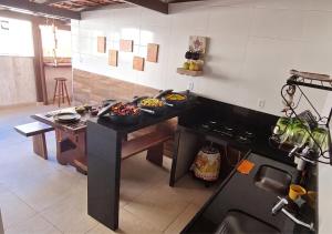 a kitchen with a table with some food on it at Apartamento 3 Quartos, Churrasqueira, Vista Mar, Varanda, 5 min da praia in Guarapari