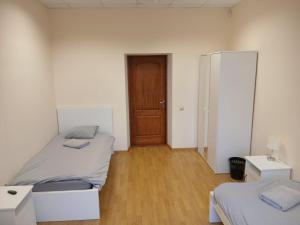 a bedroom with two beds and a wooden door at Venta stay in Ventspils