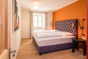 a bedroom with a bed with an orange wall at Residence Traube in Bressanone