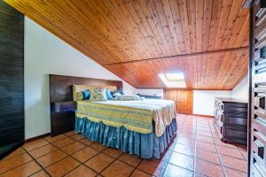 a bedroom with a bed with a wooden ceiling at Casa do Alto in Recarei