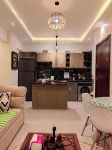 a living room with a couch and a kitchen at Zahra-Northed Chalet in El Alamein