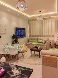 a woman sitting at a table in a living room at Zahra-Northed Chalet in El Alamein