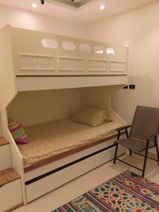 a bunk bed in a room with a chair at Zahra-Northed Chalet in El Alamein +10 photos