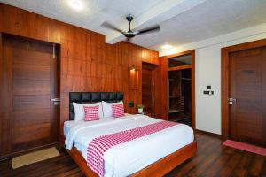 a bedroom with a large bed with red and white pillows at Open Hotel by Olive - Biranji Aqua Reatreat in Chikmagalūr