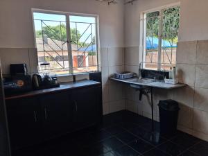 a kitchen with a sink and a window at Larry's Lodge in Livingstone +31 photos