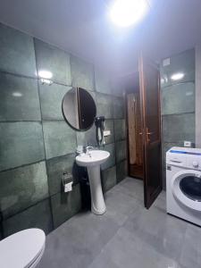 a bathroom with a sink and a toilet and a mirror at Babitouli-3 in Niabauri