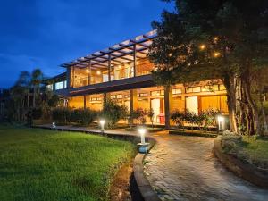 a large building with lights in front of it at Open Hotel by Olive - Biranji Aqua Reatreat in Chikmagalūr