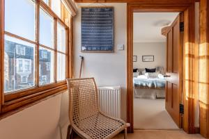 a room with a chair and a bedroom at Corner House - Elie & Earlsferry in Elie