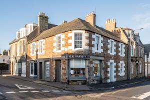 an old brick building on the corner of a street at Corner House - Elie & Earlsferry in Elie