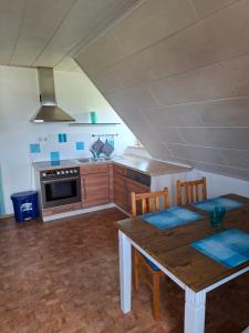 a kitchen with a wooden table and a stove at Ferienwohnung am Vogelsteig in Pegnitz