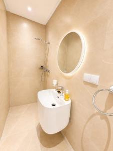 a bathroom with a white sink and a mirror at Sables D'or Appart Hôtel in Agadir +25 photos