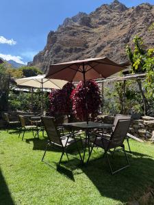 a group of tables and chairs with an umbrella at Anido House in Ollantaytambo