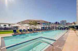 a large swimming pool with chairs and umbrellas at CozySuites at Adeline in Phoenix +59 photos