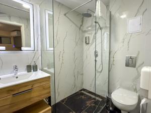 a bathroom with a shower and a toilet and a sink at Lev Or Aparthotel in Bucharest +107 photos