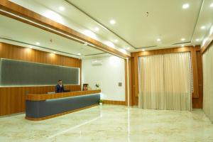 a person standing at a reception desk in a lobby at Aadyanta in Kadūr