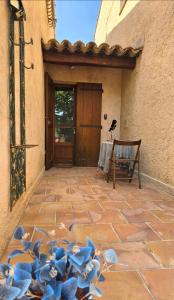 a patio with a wooden door and blue flowers at L'Orée du Loup in La Colle-sur-Loup
