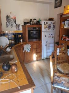 a kitchen with a white refrigerator and a table at A casetta in Bastia