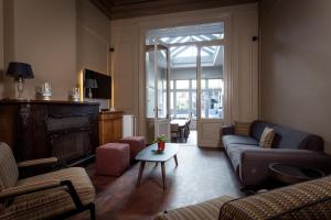 a living room with a couch and chairs and a table at Luxueus vakantiehuis in hartje Ronse met 7 slaapkamers & badkamers in Ronse