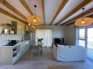 a kitchen and living room with a couch and a table at 2 Bedroom sea view studio in Onrus in Hermanus