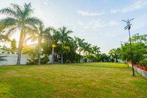 a park with palm trees and a fence at Manas Resort Udaipur in Udaipur