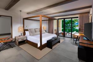 a bedroom with a bed and a living room at Unico Hotel Riviera Maya Adults Only in Akumal