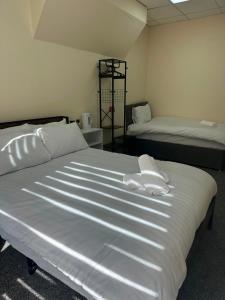 a bedroom with two beds with white sheets at Victoria Hotel Blackpool in Blackpool