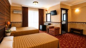 a hotel room with two beds and a television at ANADOL Hotel & Pool Central Kyrenia in Temblos