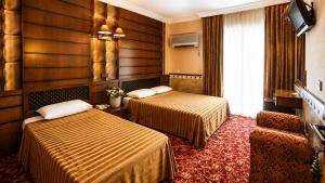a hotel room with two beds and a television at ANADOL Hotel & Pool Central Kyrenia in Temblos