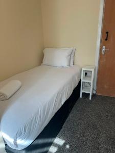 a bed in a small room with a small table at Victoria Hotel Blackpool in Blackpool