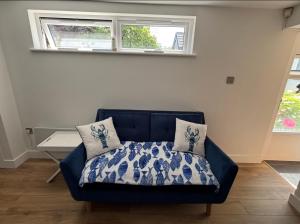 a blue couch in a room with a window at Mudeford Breeze in Mudeford