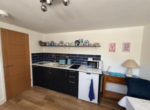a kitchen with a sink and a stove top oven at Mudeford Breeze in Mudeford