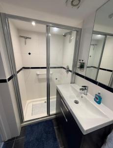 a bathroom with a shower and a white sink at Mudeford Breeze in Mudeford