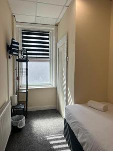 a small bedroom with a bed and a window at Victoria Hotel Blackpool in Blackpool