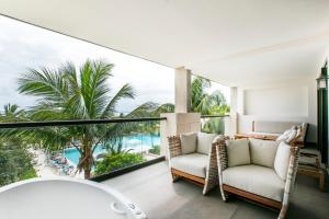 a room with a view of the ocean and palm trees at Unico Hotel Riviera Maya Adults Only in Akumal