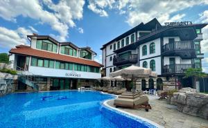 a hotel with a swimming pool in front of a building at Villa EUPHORIA in Ridovo