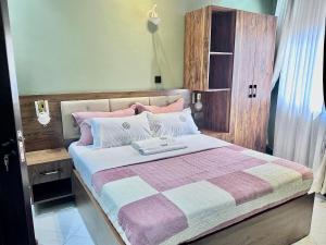 a bedroom with a large bed with a wooden headboard at El Gado Casas in Kampala +6 photos