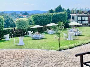 a group of tables with white chairs and umbrellas at El Gado Casas in Kampala