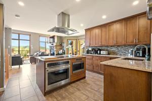a kitchen with wooden cabinets and a stove top oven at Tremblant Prestige - Clairiere 406 in Mont-Tremblant