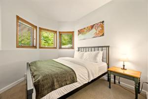 a white bedroom with a bed and a table at Tremblant Prestige - Clairiere 406 in Mont-Tremblant +28 photos