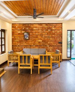 a dining room with a brick wall and a table and chairs at Summer Stays Boho in Bhīm Tāl