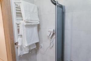 イノヴロツワフにあるSolankowy Apartamentのバスルーム(白いタオル、シャワー付)