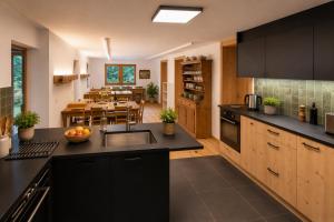 a kitchen with black cabinets and a dining room at Chalet Rosablanche, since 1929 - peace, quiet & tradition in Nendaz