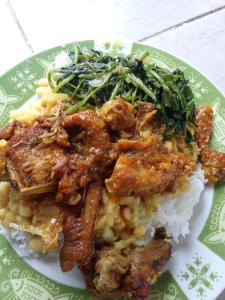 a plate of food with chicken and rice and greens at Dortoirs in La Possession