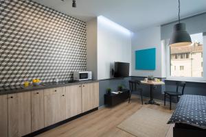 a kitchen and living room with a microwave and a table at Studio Apartments River in Rijeka