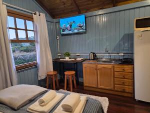 a kitchen with a bed and a tv on the wall at Vila dos Tropeiros in Lauro Müller
