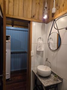 a bathroom with a sink and a mirror at Vila dos Tropeiros in Lauro Müller