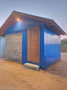 a blue building with a brown door on it at Vila dos Tropeiros in Lauro Müller