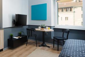 een kamer met een tafel, 2 stoelen en een bed bij Studio Apartments River in Rijeka